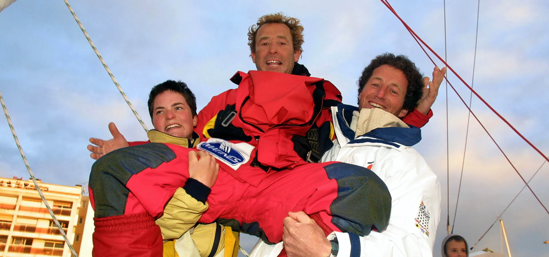 Le skipper français Roland Jourdain est soulevé par Ellen Macarthur, 2ème, et Michel Desjoyeaux, vainqueur, après son arrivée à la 3ème place dans le Vendee Globe, tour du monde à la voile en solitaire sans escale et sans assistance, le 13 Février 2001, aux Sables d'Olonne - (Photo Jacques Vapillon / Alea / Vendee Globe)