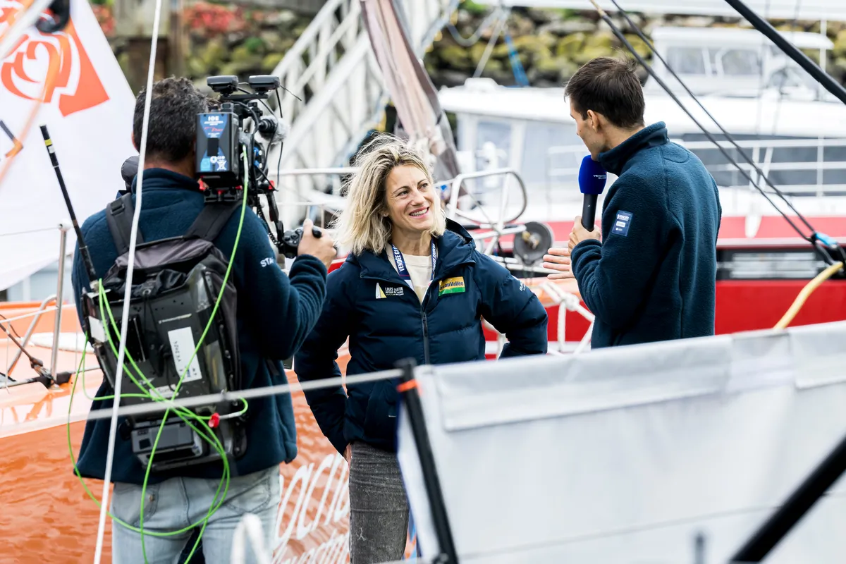 LES SABLES D'OLONNE, FRANCE - 20 OCTOBRE 2024 : Le speaker Maxime Cogny s'entretient avec le skipper de Bureau Vallée Louis Burton (FRA) et son épouse et team manager Servane Escoffier pour l'émission Vendée Live lors du pré-départ du Vendée Globe, le 20 octobre 2024 aux Sables d'Olonne, France - (Photo by Olivier Blanchet / Alea)
