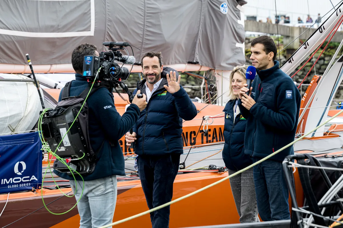 LES SABLES D'OLONNE, FRANCE - 20 OCTOBRE 2024 : Le speaker Maxime Cogny s'entretient avec le skipper de Bureau Vallée Louis Burton (FRA) et son épouse et team manager Servane Escoffier pour l'émission Vendée Live lors du pré-départ du Vendée Globe, le 20 octobre 2024 aux Sables d'Olonne, France - (Photo by Olivier Blanchet / Alea)