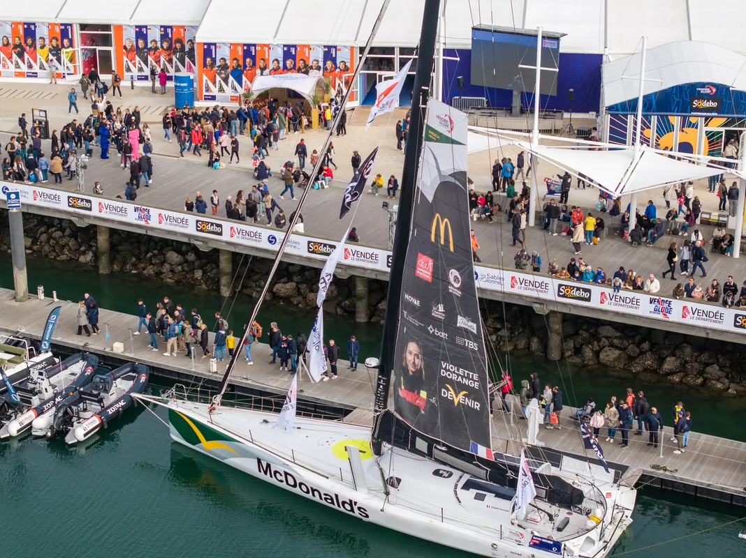 LES SABLES D'OLONNE, FRANCE - 1ER NOVEMBRE 2024 : Le stand Disney Vaiana 2 est photographié avec DeVenir, la skipper Violette Dorange (FRA), au premier plan, lors du pré-départ du Vendée Globe, le 1er novembre 2024 aux Sables d'Olonne, France. (Photo par Fred Olivier / Nefsea / Alea)