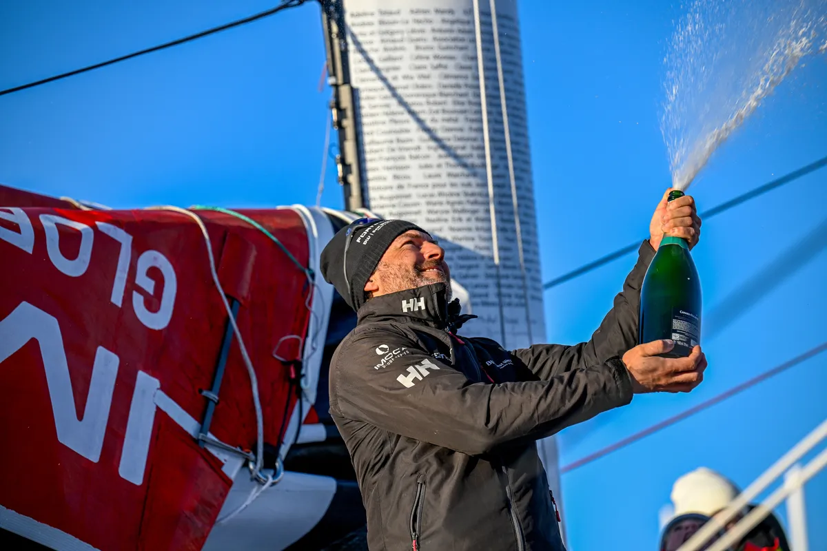 LES SABLES D’OLONNE, FRANCE - FEBRUARY 02, 2025 : Fortinet - Best Western skipper Romain Attanasio (FRA) is celebrating with champagne after taking 14th place in the Vendee Globe, on February 02, 2025 in Les Sables d'Olonne, France - (Photo by Jean-Louis Carli / Alea)