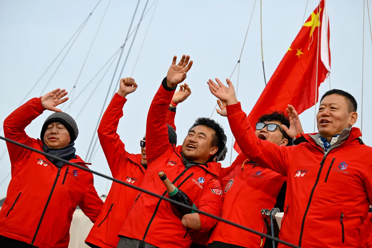 LES SABLES D’OLONNE, FRANCE - FEBRUARY 18, 2025 : Singchain Team Haikou skipper Jingkun Xu (CN) is celebrating with champagne after taking 30th place in the Vendee Globe, on February 18, 2025 in Les Sables d'Olonne, France - (Photo by Jean-Louis Carli / Alea)