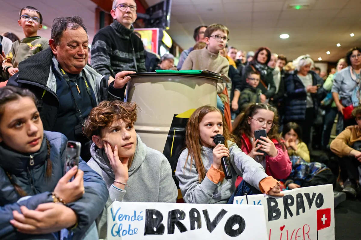"LES SABLES D'OLONNE, FRANCE - FEBRUARY 18, 2025 : Tut Gut. Sailing skipper Oliver Heer (SUI) and Singchain Team Haikou skipper Jingkun Xu (CN) are questioned by kids at the Skippers Finishers Club of the Vendee Globe, on February 18, 2025 in Les Sables d'Olonne, France - (Photo by Jean-Louis Carli / Alea)