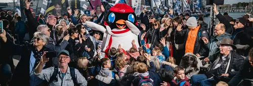 LES SABLES D'OLONNE, FRANCE - NOVEMBER 8, 2024: Mascot Adélie is posing with the crowd on pontoons, in a specific series of portraits shot at prestart of the Vendee Globe, on November 8, 2024 in Les Sables d'Olonne, France - (Photo by Jean-Louis Carli - Vincent Curutchet / Alea)
